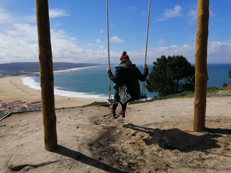 Monique auf der Schaukel mit Blick auf Nazaré, Portugal